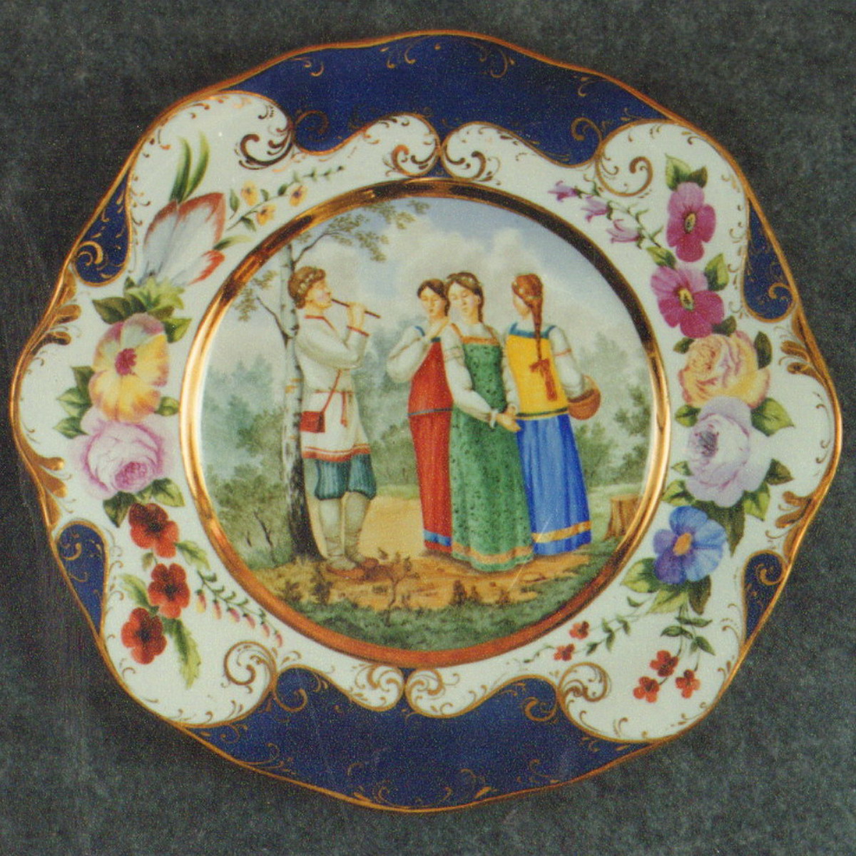 Wall Plate. Young Ladies and a young Sheferd. Over Glasour Painting on Porcelain. D 27 cm